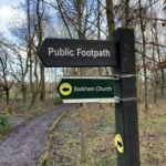 Photo of a footpath waymarker pointing to Barkham Church.