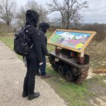 Photo of two of our wardens looking at an information panel mounted on a part of a tank track.