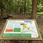 An information sign says "Welcome to Blandford Woods" and explains that Malta Barracks used to stand here.