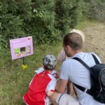 Photo of a family crouched down to read a treasure hunt clue.