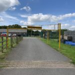 Photo of the entrance to the car park. Shows a 2m height barrier across a tarmac entrance.